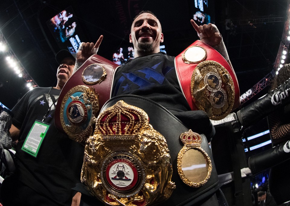 Ward poses with his belts in the ring