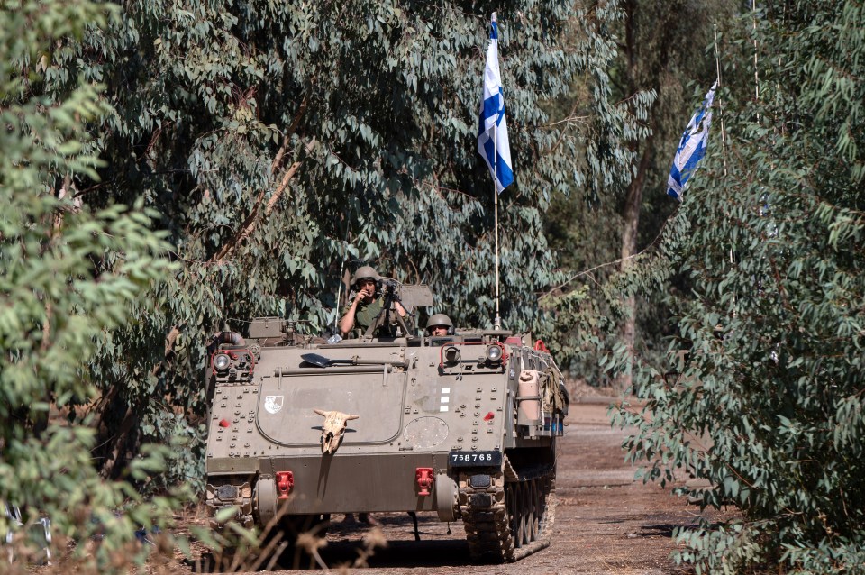 Israeli soldiers aboard a tank at an area near the border with Lebanon