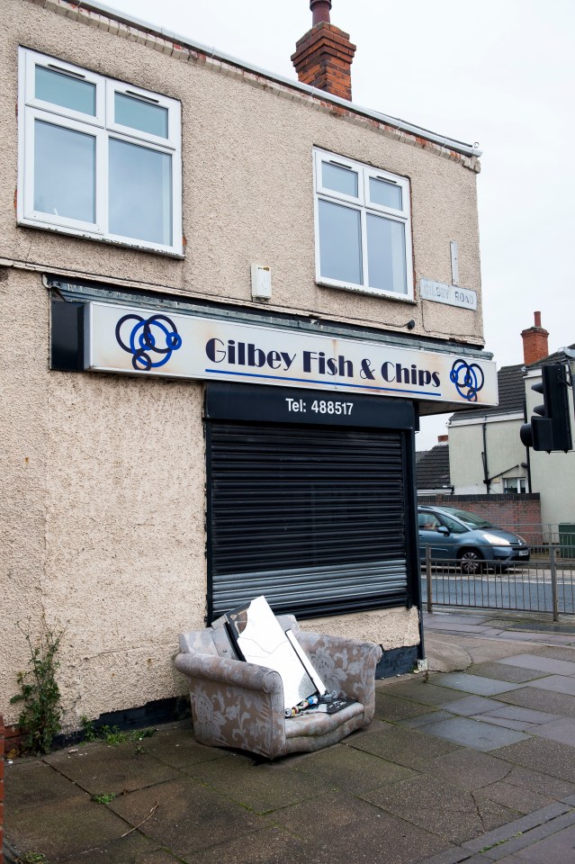 An abandoned settee sits outside the chip shop