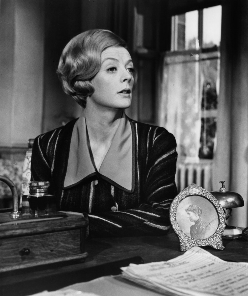 a black and white photo of a woman sitting at a desk