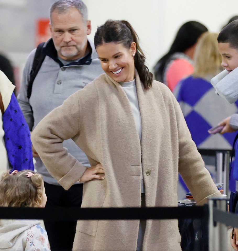 Coleen was in high spirits as she queued for her luggage