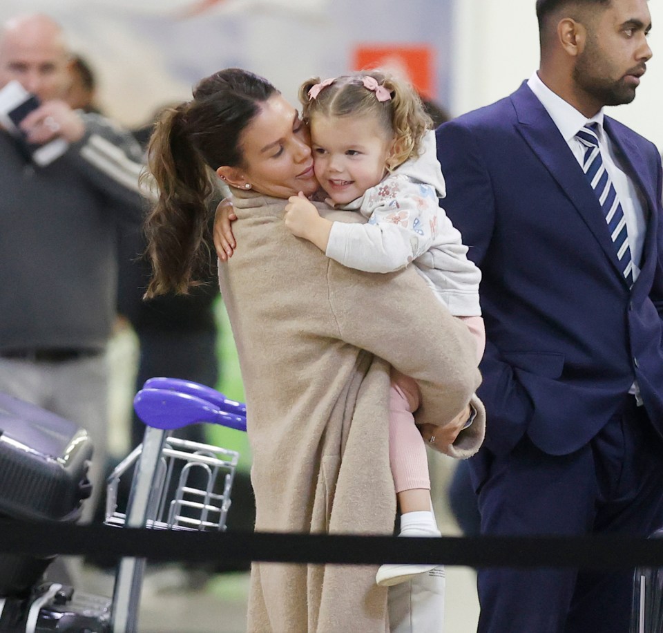 Rebekah was snapped holding daughter Olivia at the airport