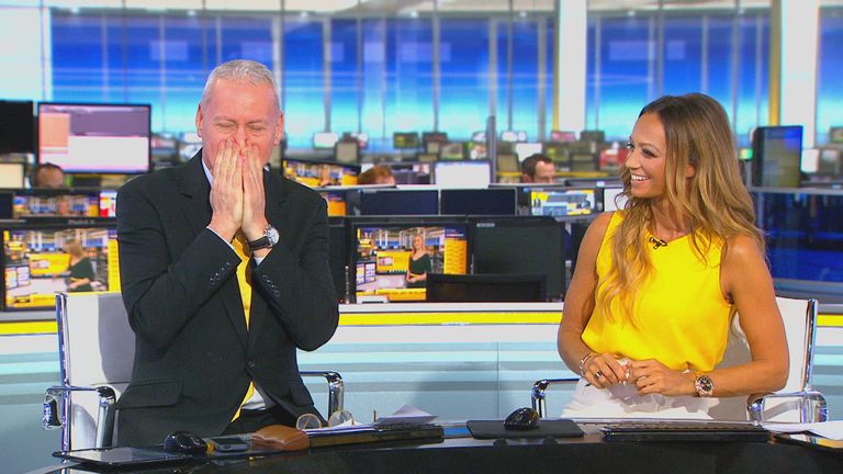 a man in a suit is laughing next to a woman in a yellow top