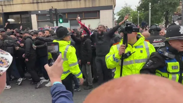 Police form a barrier between Toon and PSG fans before the game