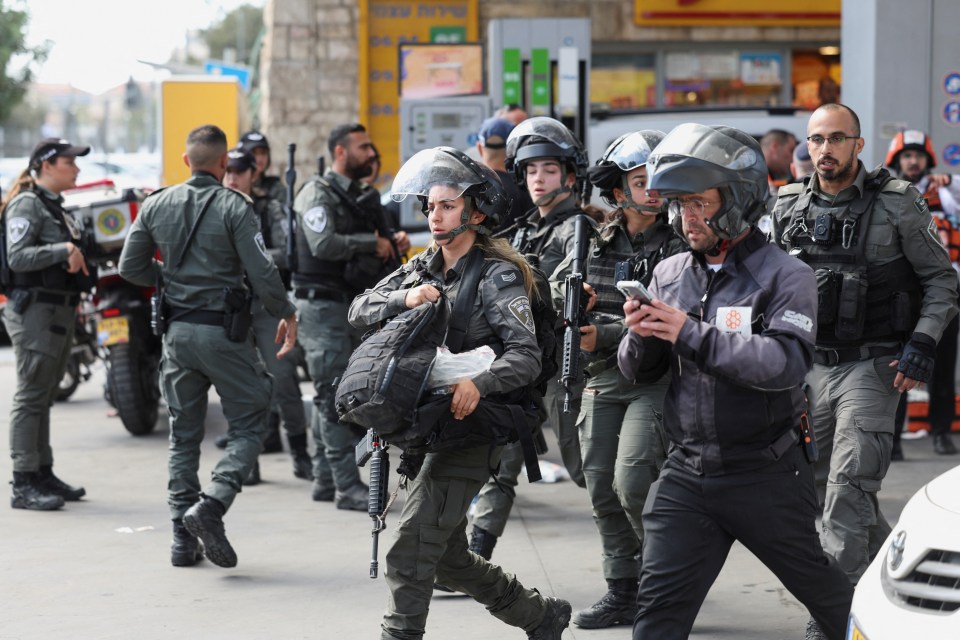 Armed cops rush to the scene of the terror attack today