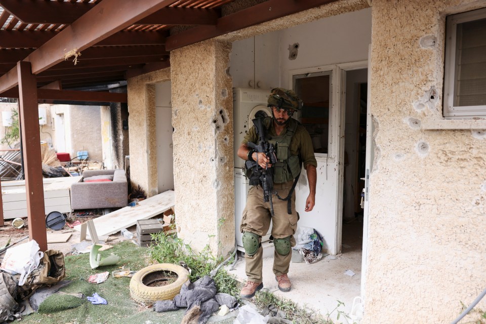 An Israeli soldier stands at the entrance to a building in the town