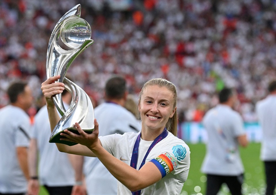 (FILES) In this file photo taken on July 31, 2022 England's midfielder Leah Williamson poses with the trophy as England players celebrate after their win in the UEFA Women's Euro 2022 final football match between England and Germany at the Wembley stadium, in London. - England's midfielder Leah Williamson is one of 1,107 people who have been awarded this year in a list signed for the first time by King Charles III. These royal awards are given twice a year, on New Year's Day and on the King's official birthday, always celebrated in June, regardless of the monarch's actual date of birth (14 November 1948 for Charles III). (Photo by JUSTIN TALLIS / AFP) / No use as moving pictures or quasi-video streaming. Photos must therefore be posted with an interval of at least 20 seconds. (Photo by JUSTIN TALLIS/AFP via Getty Images)