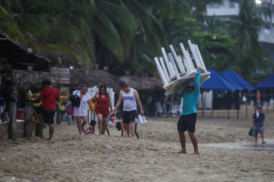 People leaving and packing up the beach as the hurricane makes it way towards them