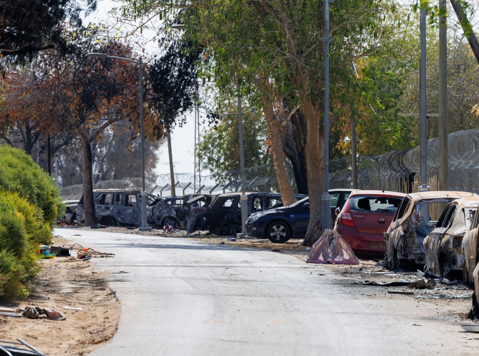 Burnt cars near the fence after Hamas fighters stormed the kibbutz