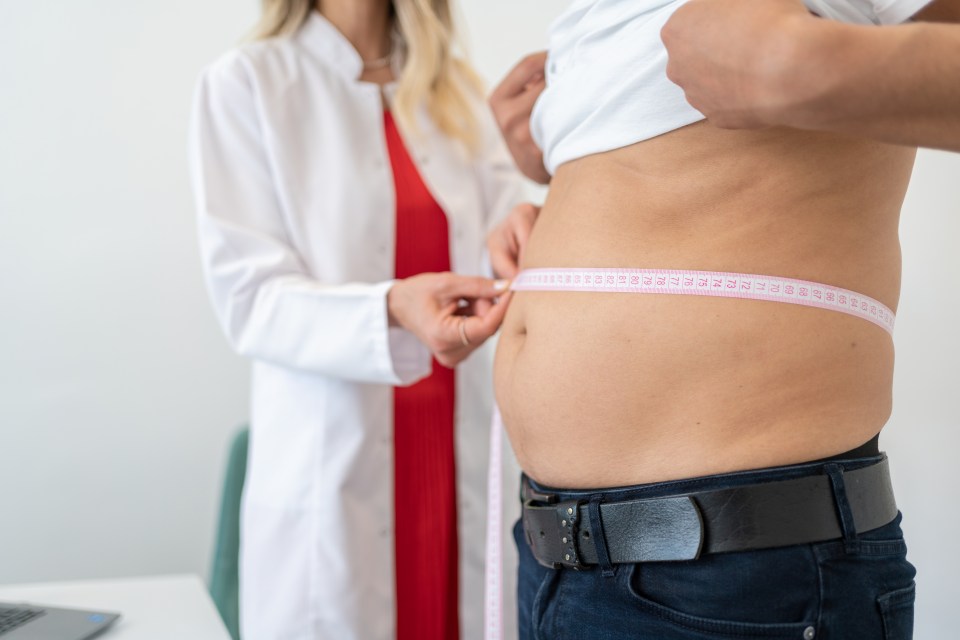 Nutritionist Measuring Patient’s Waist During Consultation In Office