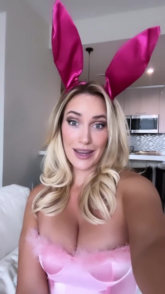 a woman wearing pink bunny ears takes a selfie