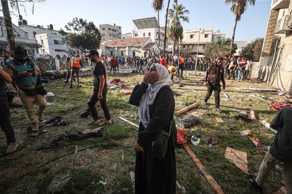 A Palestinian cries at the garden of Al-Ahli Arabi Baptist Hospital after it was hit in Gaza on October 18