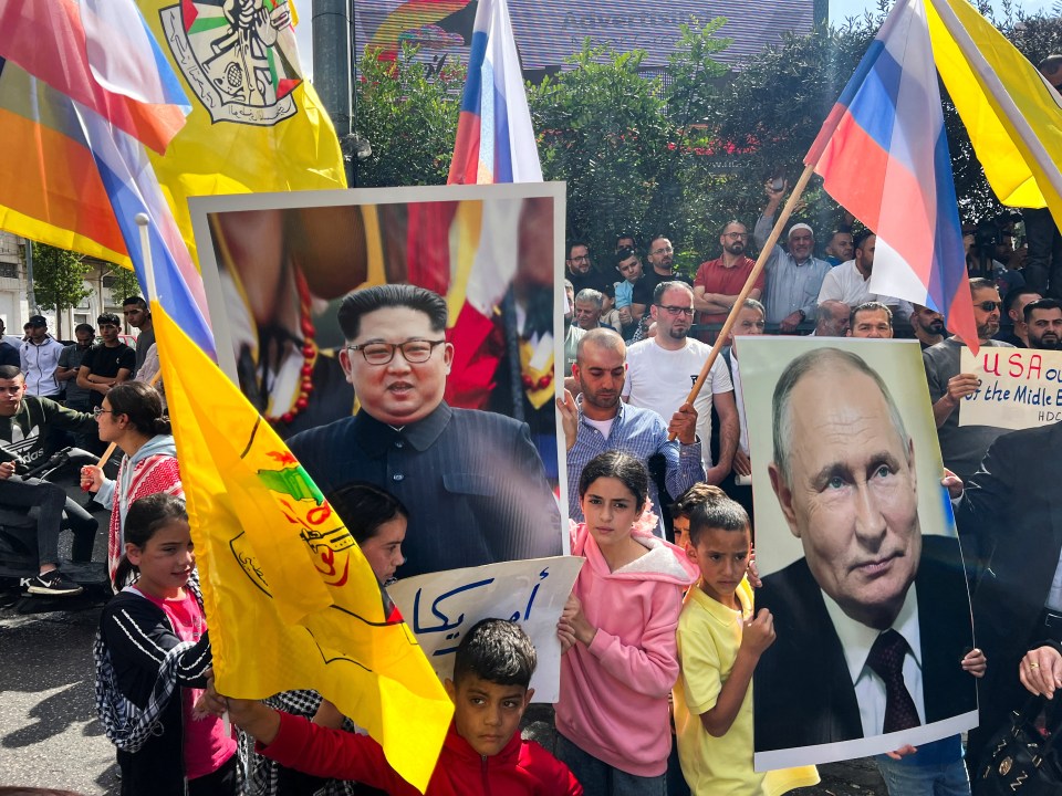 Palestinians hold pictures of Putin and Kim Jong-un during a protest this week in the West Bank