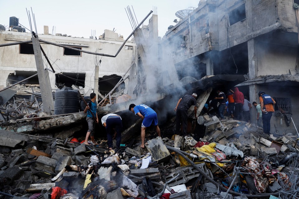 People search for survivors under a crushed house