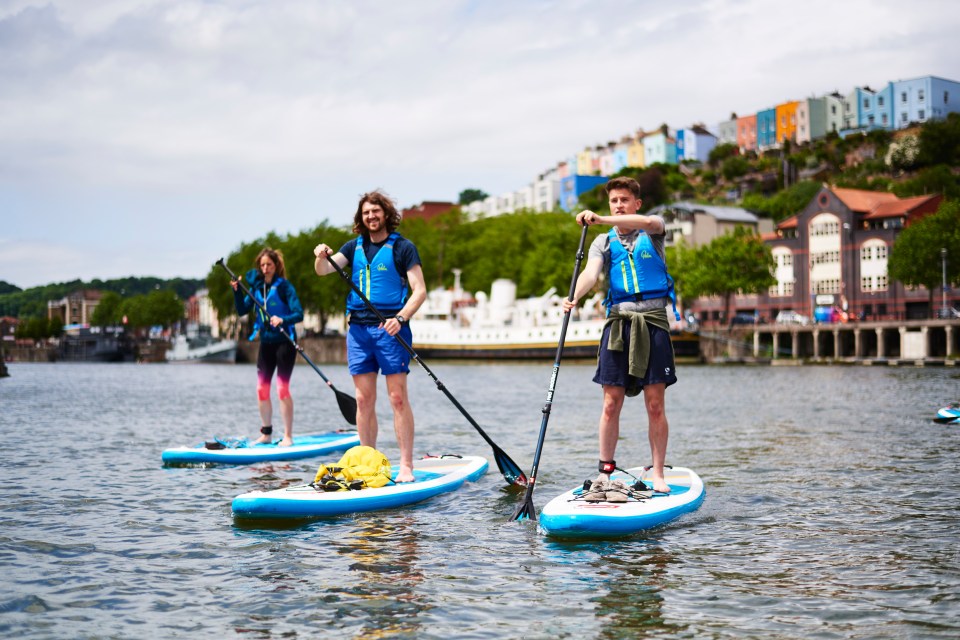 Explore Bristol's Harbourside on a stand up paddleboarding session, surrounded by colourful cottages