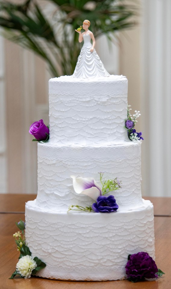 The cake is topped off with a bride kissing a frog