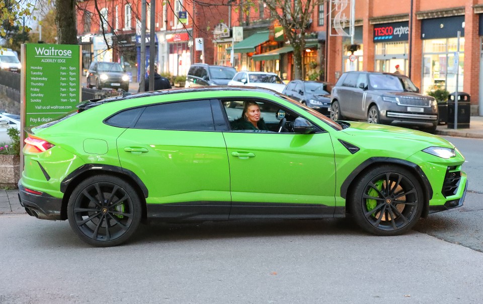 She was snapped behind the wheel of her lime green £200,000 supercar