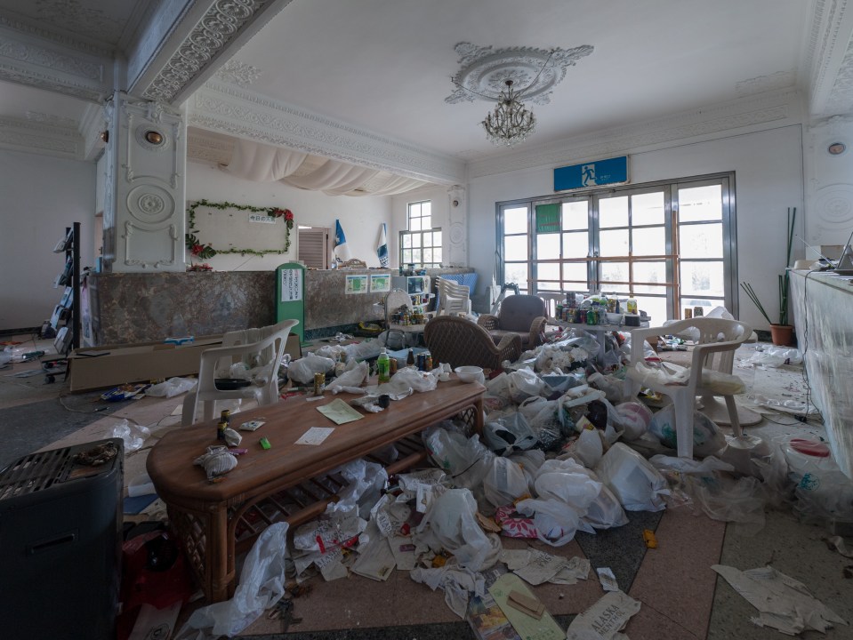 A once-stylish hall now lies littered with debris and rubbish left behind