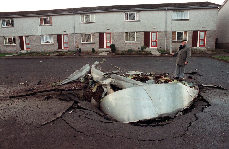 A local resident stands next to one of the four engines of the US-bound flight, which was blown up over Lockerbie