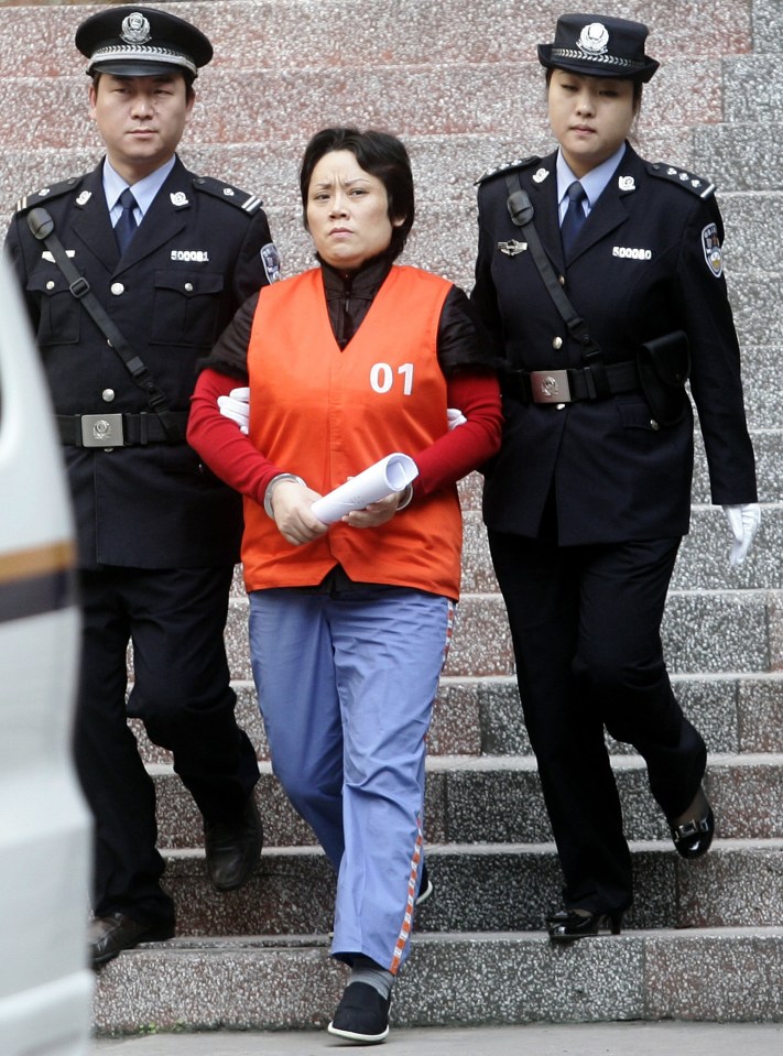 Forty-six-year-old ‘Godmother’ Xie Caiping led from court after her sentencing in 2009