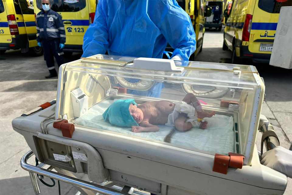 Egyptian medics wheel a premature Palestinian baby evacuated from Gaza to an ambulance on the Egyptian side of the Rafah border crossing