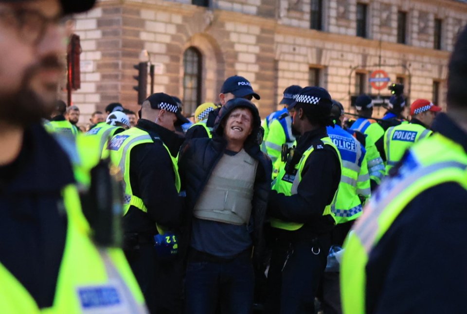 A man is restrained as clashes with police erupt in Parliament Square