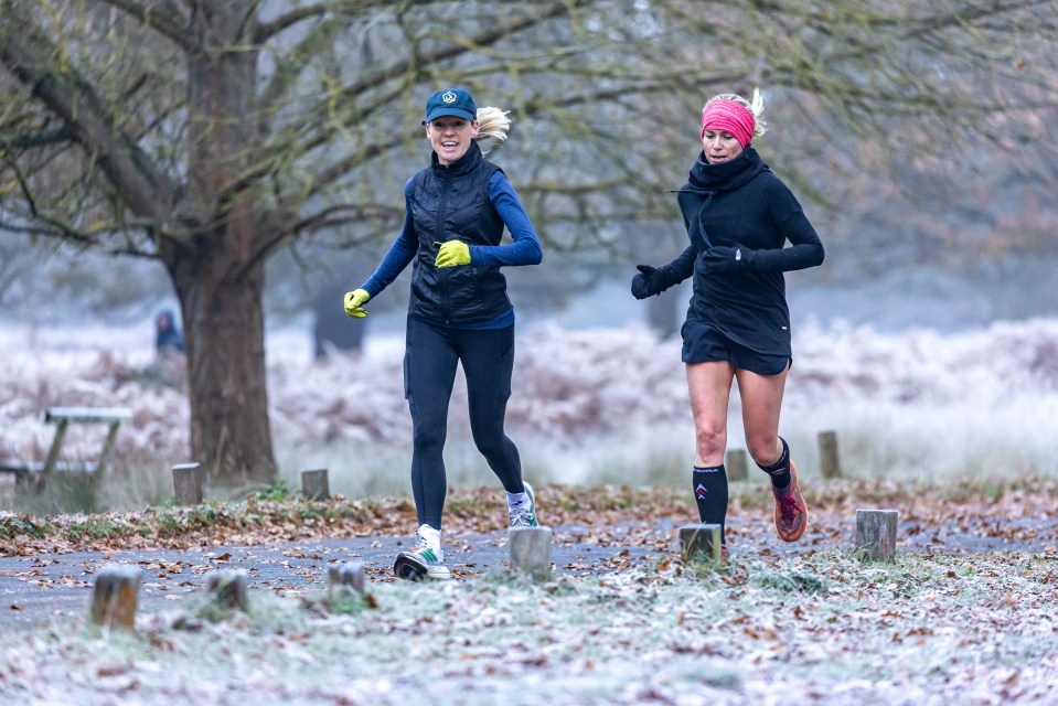 Runners making their way through a frost Richmond Park in south-west London this morning