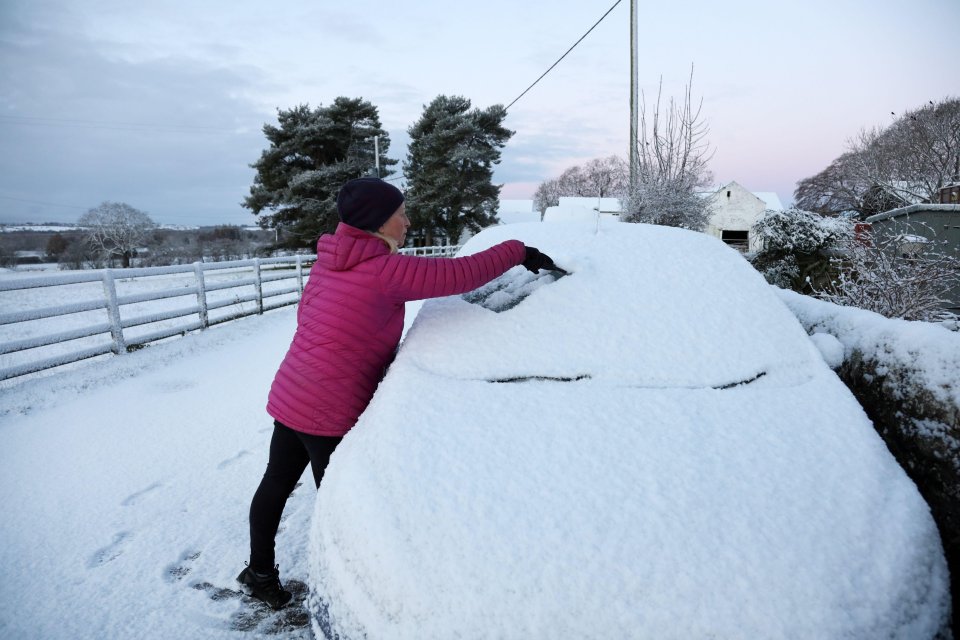 A motorist clears the snow away from their car in County Durham