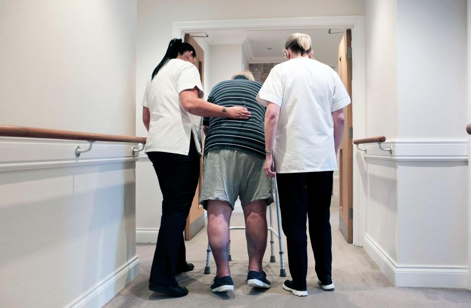 2BGG6R7 Staff assist a man using a zimmer frame at a residential care home in Redcar, UK. 2/2/2018. Photograph: Stuart Bolton.