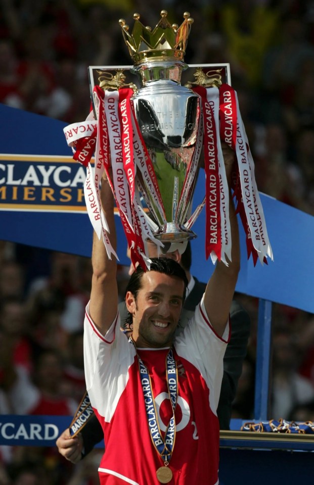 a man holding up a trophy that says barclaycard on it