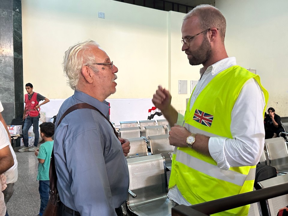 A Brit official speaks to a recent arrival at Rafah crossing on the border of Gaza and Egypt as dozens of UK citizens make it out of the Strip