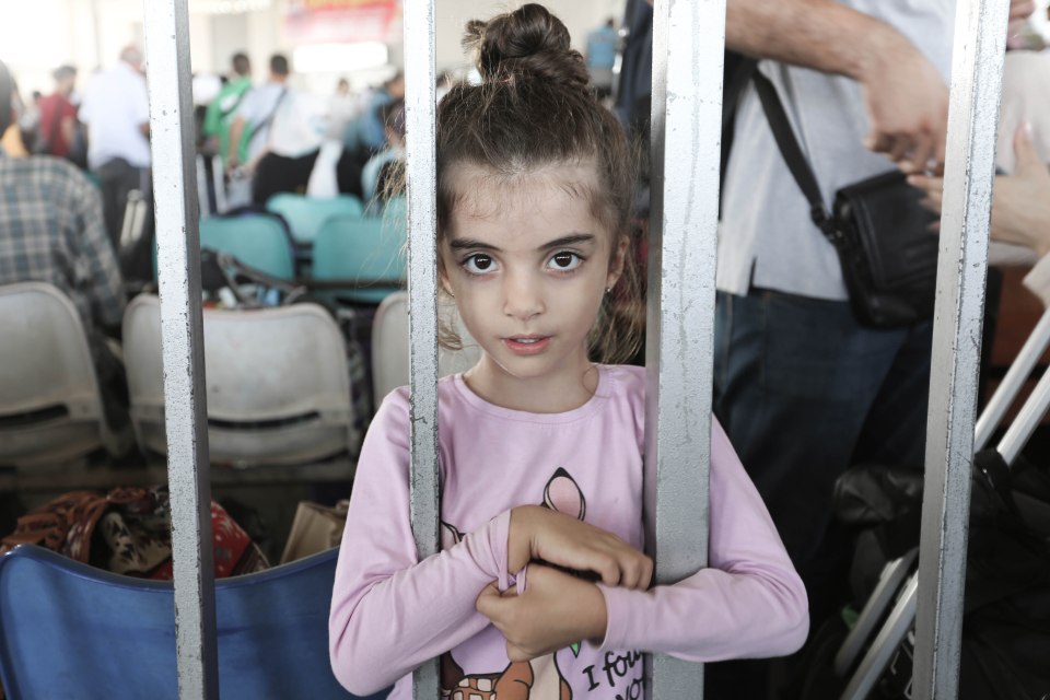 People walk through a gate to enter the Rafah border crossing to Egypt in the southern Gaza Strip on November 1, 2023. Scores of foreign passport holders trapped in Gaza started leaving the war-torn Palestinian territory on November 1 when the Rafah crossing to Egypt was opened up for the first time since the October 7 Hamas attacks on Israel. (STR \ apaimages/APAImages/Polaris)