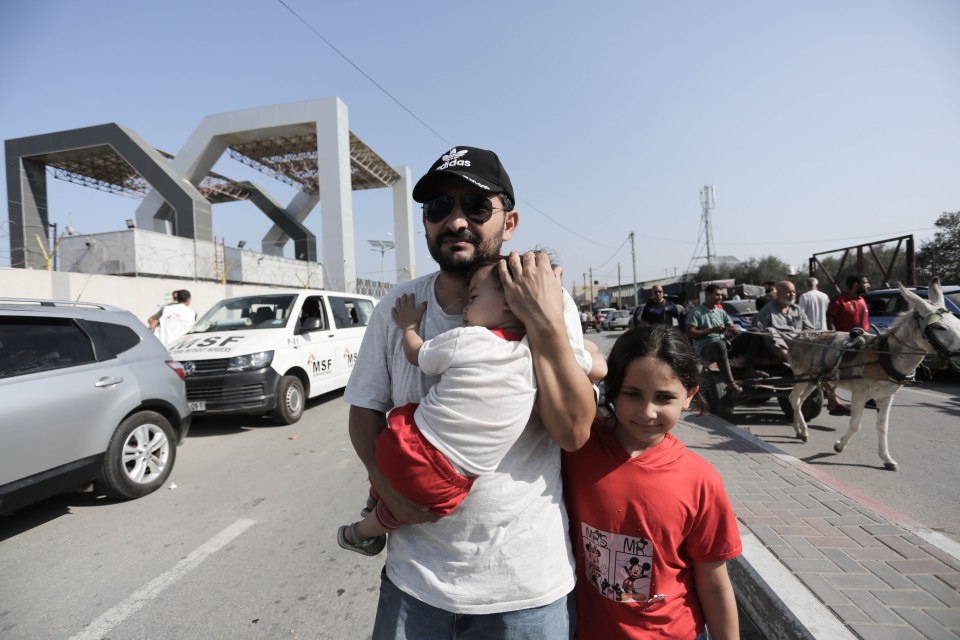 People walk through a gate to enter the Rafah border crossing to Egypt in the southern Gaza Strip on November 1, 2023. Scores of foreign passport holders trapped in Gaza started leaving the war-torn Palestinian territory on November 1 when the Rafah crossing to Egypt was opened up for the first time since the October 7 Hamas attacks on Israel. (STR \ apaimages/APAImages/Polaris)