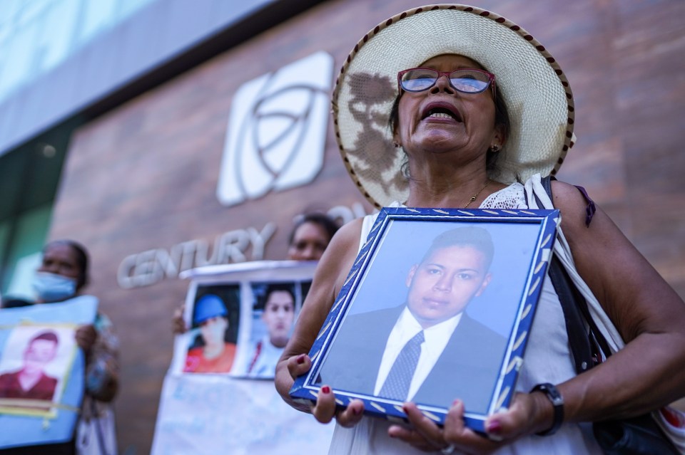 A woman holds a picture of her jailed relative during a protest against wrongful detention in El Salvador