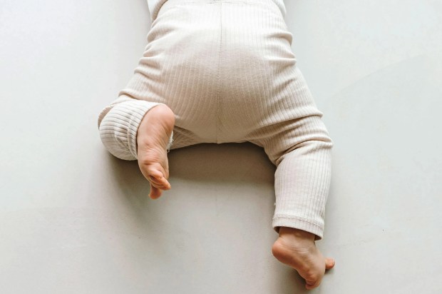 Baby's legs on floor. Minimal family, baby concept. Copy space.