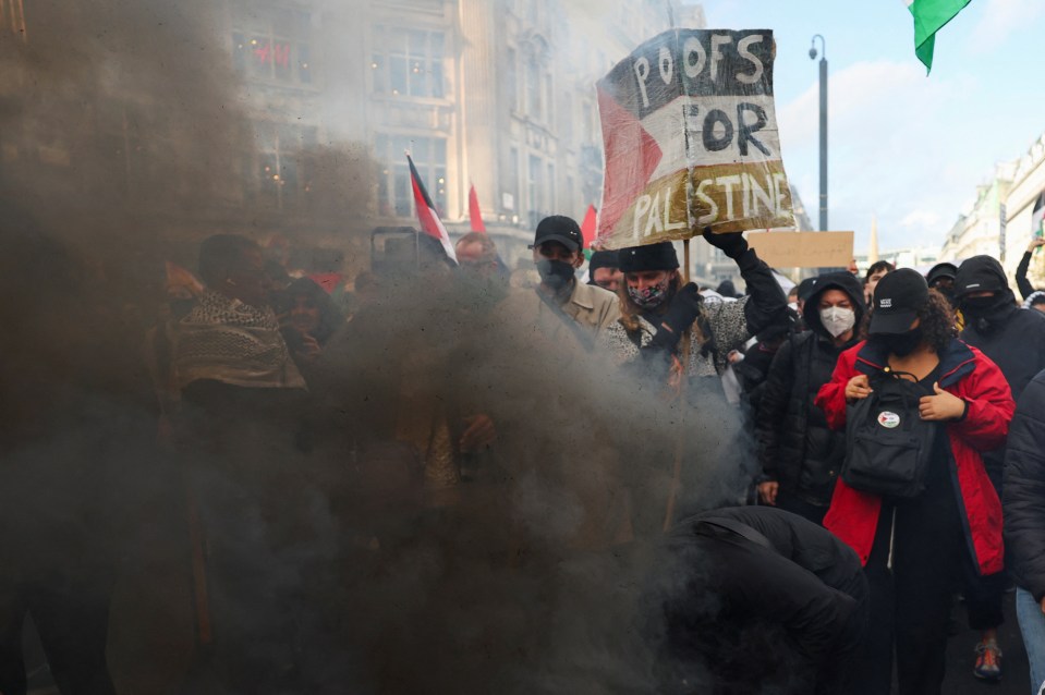 Demonstrators use a smoke flare as they protest in solidarity with Palestinians