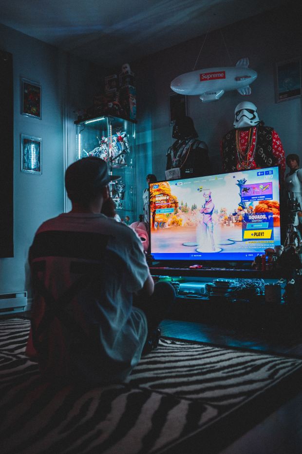 a man playing a video game with a supreme sign above him