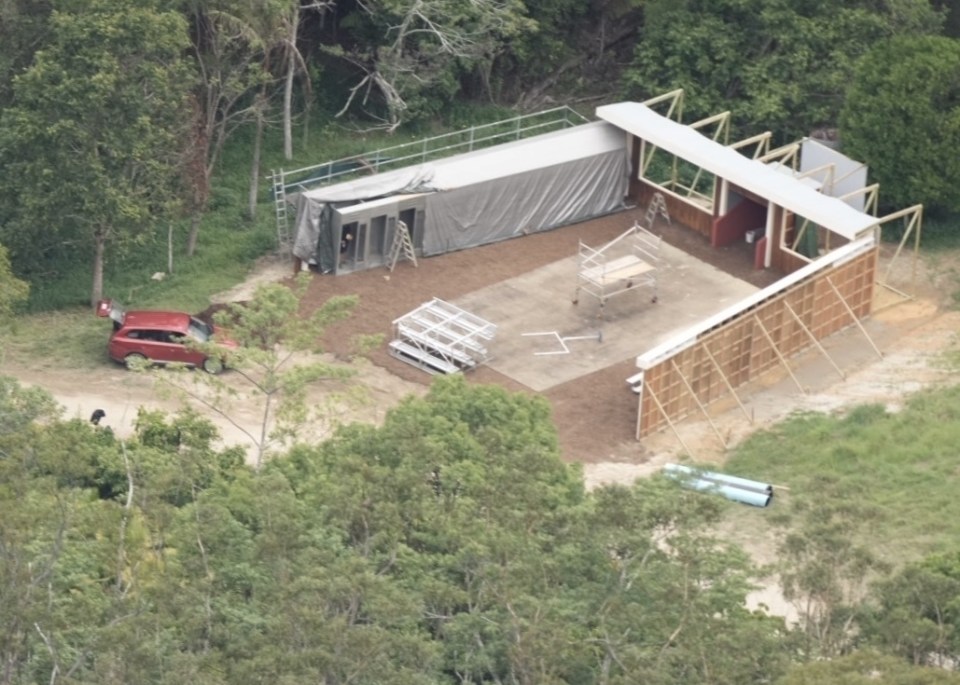 Crew can be seen building a small arena with stands and a cage