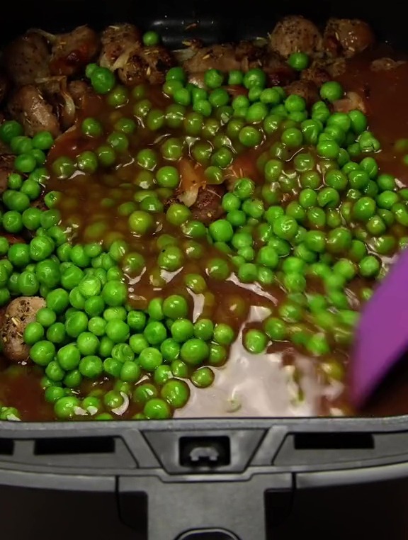 After your sausages have browned, add 200g of peas and 300ml gravy to the sausage mix, and stir them together