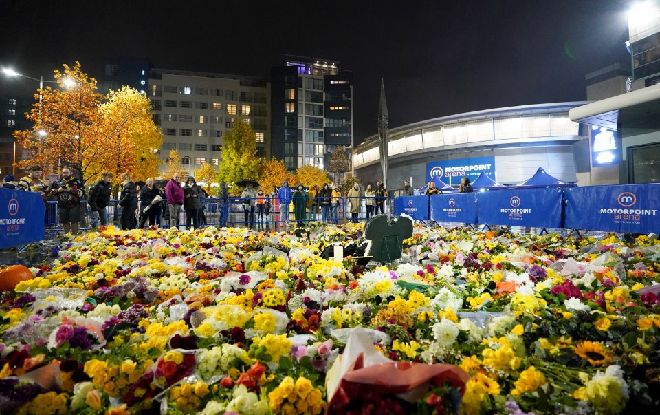 Fans look at floral tributes outside the Motorpoint Arena, Nottingham, in memory of Johnson