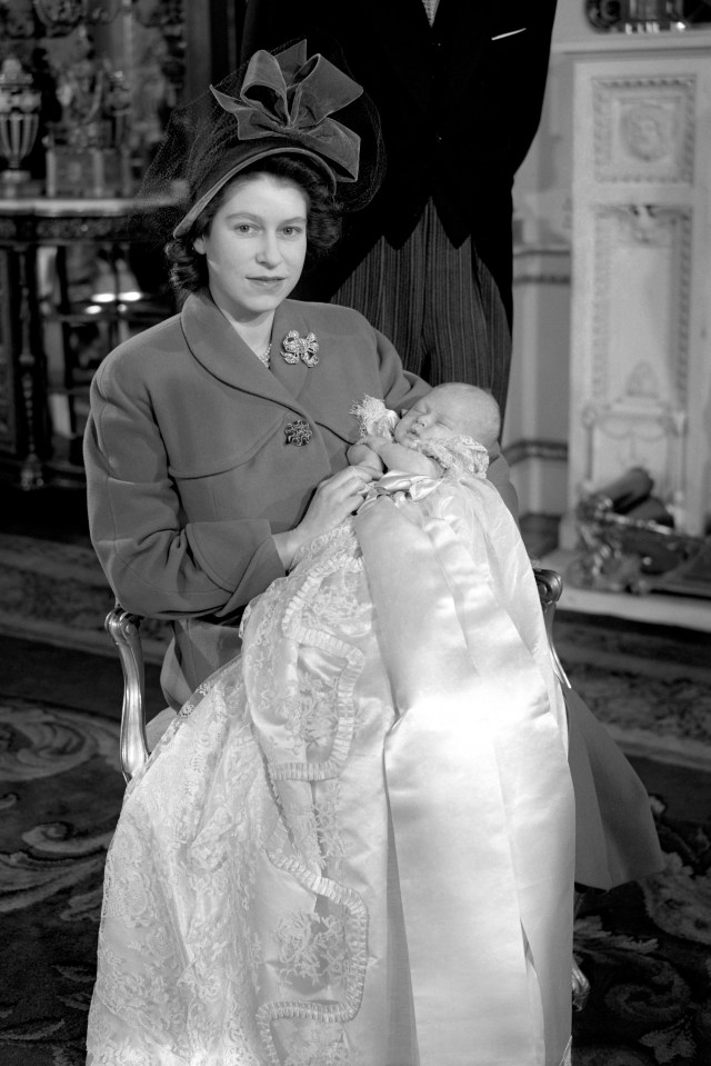 Princess Elizabeth holding her infant son, Prince Charles, after his christening ceremony at Buckingham Palace