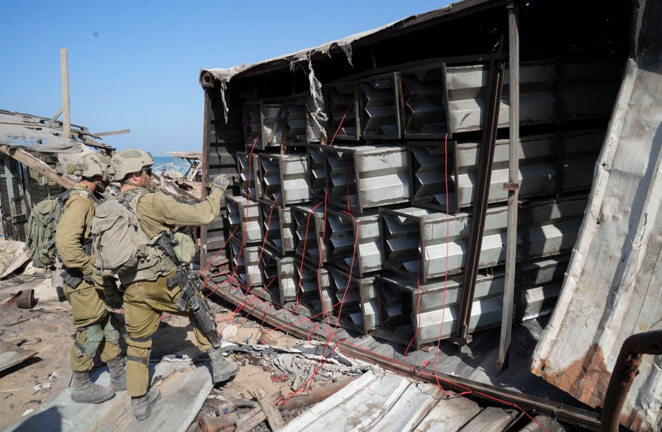 Israeli soldiers prepare explosives to blow up a Hamas arms dump on a beach in Gaza