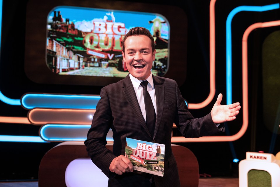 a man in a suit and tie holds a sign that says big quiz