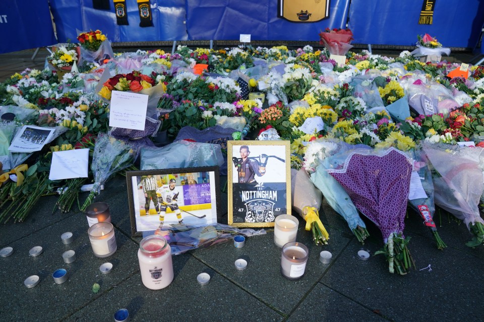 Lit candles among the flowers and messages left in tribute Johnson