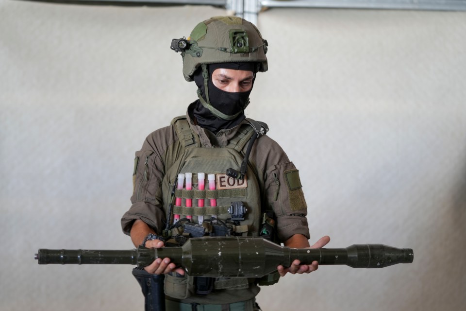 The masked officer shows The Sun part of the devastating Hamas haul