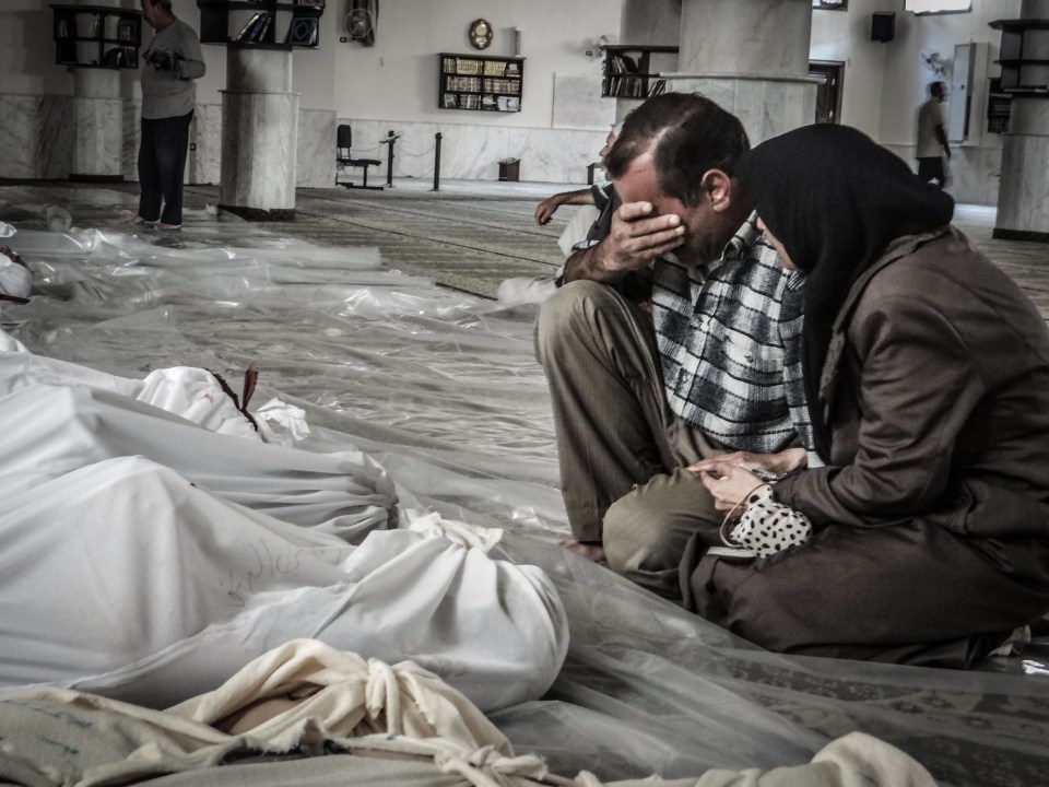 A mother and father weep over their child’s body who was killed in the chemical attack in Ghouta, August 2013