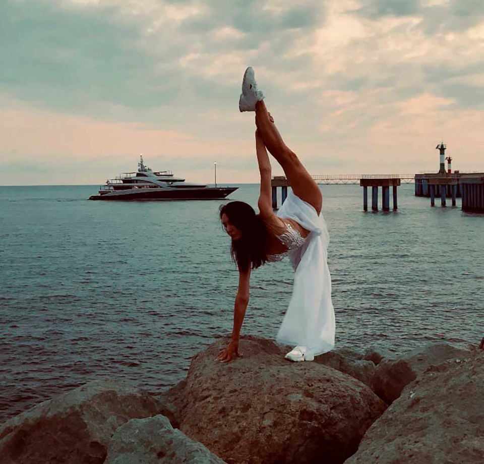 Natalya Belugina is seen posing in front of Putin’s yacht Victoria