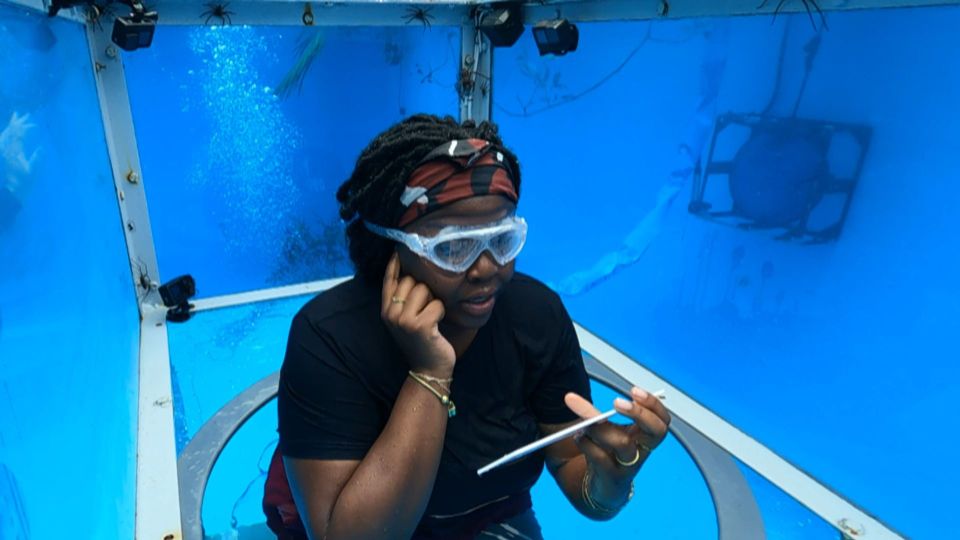 Nella reads out a question in an underwater container