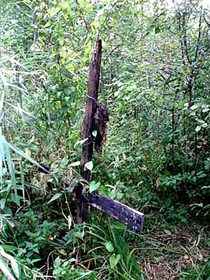 An upside down cross marked the burial plot of the limbs, hearts, scalps, breasts and genitals of the victims