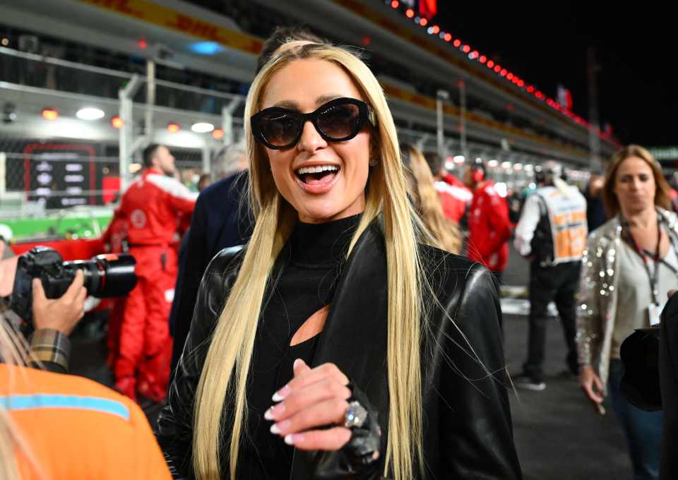 Paris Hilton could not hide her smile as she walked down the pit lane